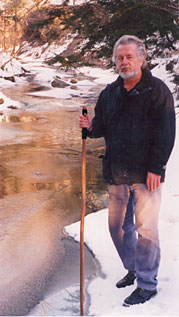 Hiker beside an icy creek in the winter